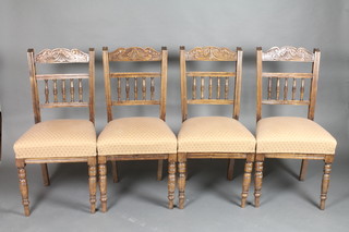 A set of 4 Edwardian carved walnut bar back dining chairs with bobbin turned decoration, raised on turned supports