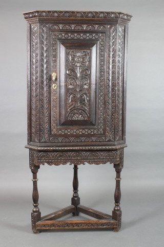 A Victorian carved oak corner cabinet with moulded cornice, the interior fitted shelves enclosed by a panelled door, raised on turned and block supports 34"h x 30"w x 18"d 