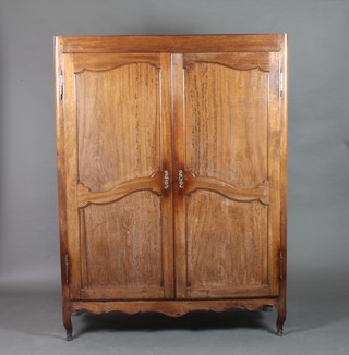 An 18th/19th Century French fruitwood armoire with shelved interior enclosed by panelled doors, raised on cabriole supports 66"h x 50"w x 19 1/2"d