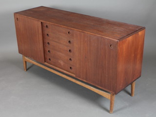 A 1960's Danish teak sideboard, fitted 5 long drawers flanked by cupboards, raised on turned supports 30 1/2"h x 59"w x 18"d 