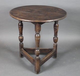 A circular oak cricket table, raised on turned supports with box frame stretcher 29" x 29"