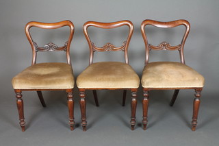 3 Victorian rosewood spoon back dining chairs with carved mid rails and upholstered seats, on turned supports 