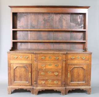 A George III oak dresser, the raised back with moulded cornice fitted 2 shelves, the breakfront base fitted 4 long drawers flanked by a pair of drawers above double cupboards enclosed by panelled doors, raised on bracket feet 73"h x 68"w x 19"d 