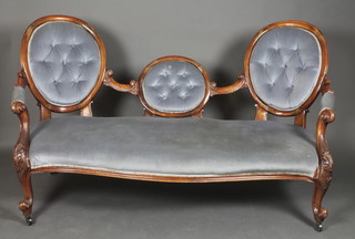 A Victorian carved mahogany show frame double spoon back settee upholstered in blue buttoned dralon and raised on cabriole supports 37 1/2"h x 67 1/2"w x 28"d 