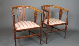 A pair of Edwardian inlaid mahogany tub slat back chairs with upholstered seats, raised on turned supports 