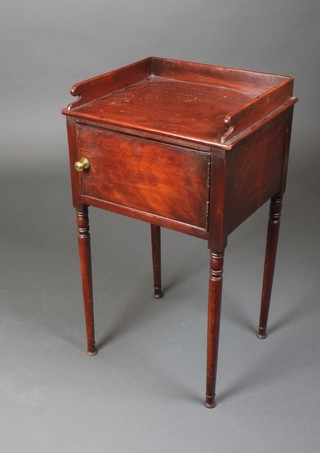 A 19th Century rectangular mahogany bedside cupboard with three-quarter gallery enclosed by a panelled door, raised on turned supports 29"h x 16"w x 14"d on turned supports