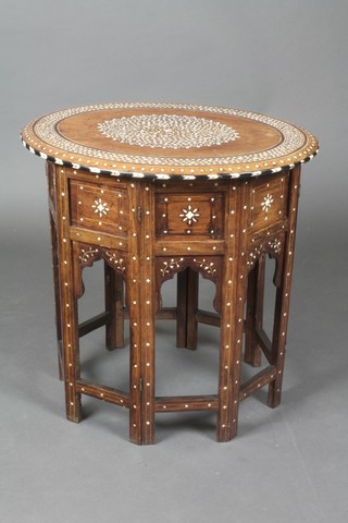 An oval Moorish style occasional table raised on an octagonal panelled folding base 22"h x 22"w x 17 1/2" diam.