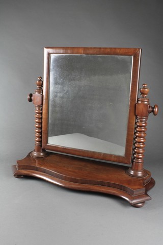 A Victorian square plate dressing table mirror contained in a mahogany swing frame with ring turned columns to the side, base of serpentine outline 21 1/2"h x 27"w x 10"d 