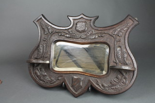 An Edwardian rectangular shaped bevelled plate mirror contained in a carved oak shield shaped frame with 2 shelves, dated 1906 17 1/2"h x 23"w 