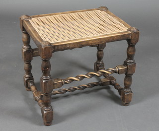 An oak stool with woven cane seat, raised on turned and block supports with spiral turned stretchers 18"h x 20"w x 15"d 