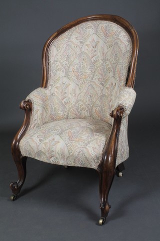 A Victorian mahogany show frame armchair upholstered in tapestry buttoned back material, raised on cabriole supports