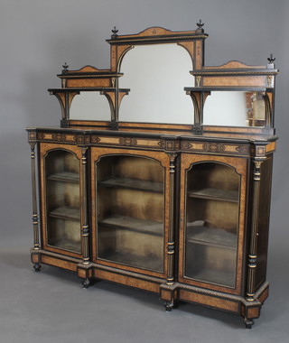 A Victorian ebonised and figured walnut chiffonier sideboard, the raised triple plate mirrored back flanked by a pair of shelves above 3 cupboards fitted shelves enclosed by arched panelled doors supported by turned and fluted columns having gilt metal mounts throughout, the centred door is numbered 09533, 69"h x 96 1/2"w x 16"d  