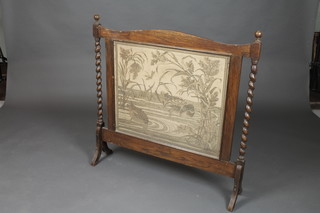 An Art Deco oak fire screen with machine made tapestry panel to the centre, having spiral turned columns to the sides 36"h 