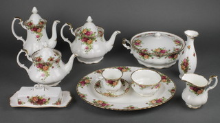A Royal Albert Old Country Roses tea and dinner service comprising 1 large teapot, 1 small teapot, 1 coffee pot, 1 small sauce boat, an oval meat plate, 1 vase, 2 shoe vases, 2 condiments, a bell, a basket, 2 milk jugs, 1 cream jug, 12 tea cups, 13 saucers, 5 coffee cups, 6 saucers, 3 section cake stand, 2 pickle dishes, 6 small plates, 12 medium plates, 6 dinner plates, 1 slop bowl, 2 sugar bowls, 2 oval dishes, butter dish and cover, 5 dessert bowls, 5 napkins and 4 place settings  