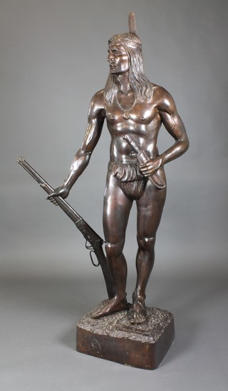 After Frederic Remington, a three-quarter life size bronze figure of a standing  Native Indian with bowie knife and Winchester rifle, raised on a naturalistic base, bears signature, 70" high to top of feather   