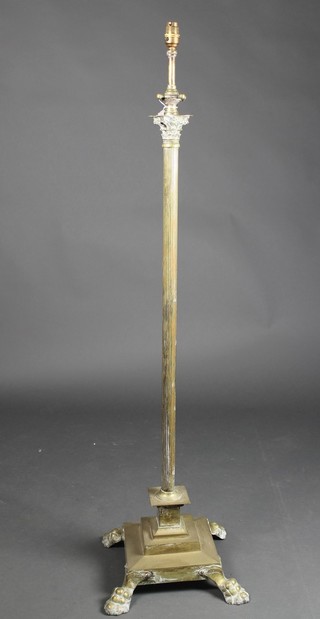 A brass adjustable standard lamp with reeded column and Corinthian capital, raised on a stepped base  