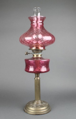 A Victorian ruby glass oil lamp reservoir raised on a brass fluted column with red glass shade 26"h 