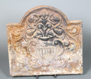An arched cast iron fire back decorated an urn 21"h x 21 1/2"w 
