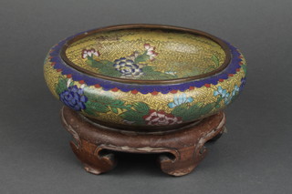 A circular yellow and blue cloisonne enamelled bowl with floral decoration, raised on a hardwood stand 