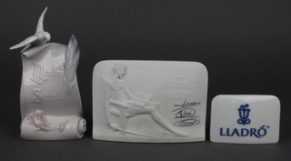 A Lladro rectangular porcelain table sign 2", a 1985 Lladro Collectors Society plaque decorated Don Quixote and 3 signature 4", a 1998 Lladro Society plaque in the form of a scroll surmounted by a dove 6"