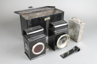A rectangular Japanned metal box containing 2 vintage cycle lamps with fitting and oil can