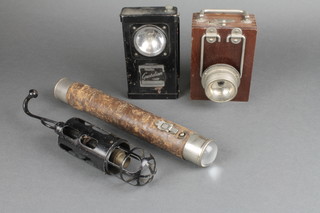 A Whetstone traffic lamp, a wooden cased lamp, a work shop inspection lamp and a cylindrical leather cased torch 