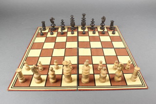 A black and white carved wooden "Regency" patterned chess set with carved board 