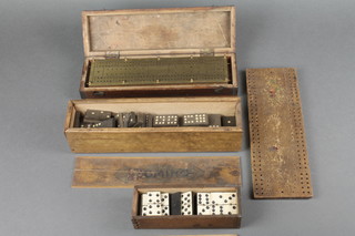 A brass and oak cribbage board contained in a mahogany case with hinged lid, a wooden cribbage board, a bone domino set - 6 spot and a 9 spot domino set  
