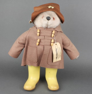 A Paddington bear with yellow boots, complete with luggage label 