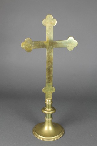 A brass cross, raised on a circular spreading base 21" high 