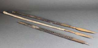 An Eastern spear with 9" blade, 1 other spear with 9 1/2" blade slightly barbed and a carved wooden shaft 
