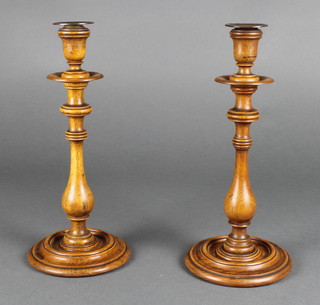 A pair of turned oak candlesticks with copper sconces 13" 