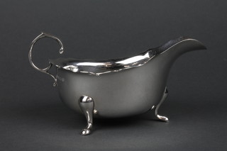 A silver sauce boat with cut rim, S scroll handle and hoof feet 148 grams