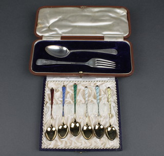 A cased silver fork and spoon, Sheffield 1911 and a cased set of 6 silver gilt guilloche enamel coffee spoons