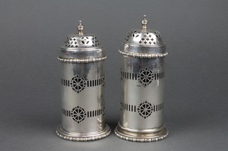 A near pair of pierced silver shakers with blue glass liners, approx 208 grams