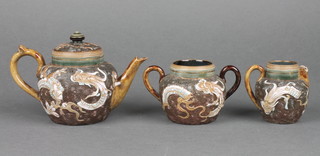 A Doulton Lambeth chinoiserie style 3 piece miniature tea service with teapot 3", twin handled sugar bowl 2" and milk jug 2" (spout chipped),  decorated dragons, base impressed Doulton Lambeth and incised JW  