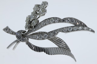 An 18ct white gold floral spray diamond brooch comprising seven eliptical stones and 39 brilliant cut stones in a bright cut mount 