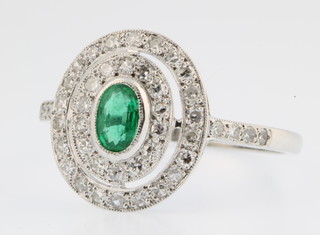 An 18ct white gold emerald and diamond cluster ring, size P 