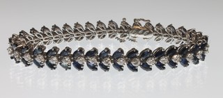 An 18ct white gold sapphire and diamond articulated floral bracelet comprising 36 brilliant cut diamonds and 72 oval cut sapphires