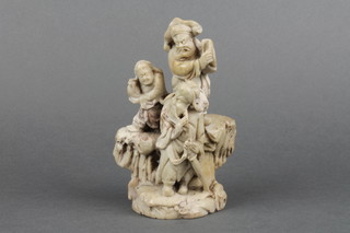 A carved soapstone seal with 3 figure handle