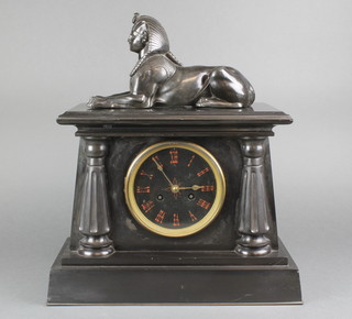 A French 8 day striking mantel clock in the Egyptian taste with Roman numerals, contained in a black marble case with columns to the side and surmounted by a figure of a sphynx 