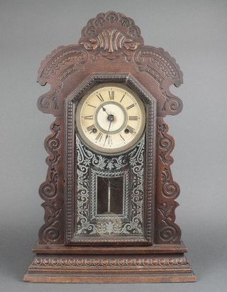 An American Ansonia striking shelf clock with paper dial and Roman numerals contained in a carved wooden case 