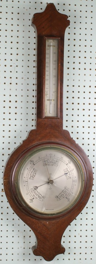A 1930's aneroid barometer and thermometer with silvered dial contained in a mahogany wheel case  