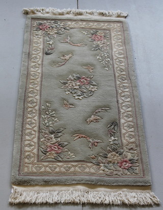 A green ground floral patterned Chinese rug decorated birds and butterflies 62" x 29 1/" 