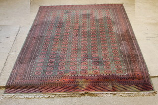 A machine made green ground Bokhara style rug, some staining, 131" x 99" 