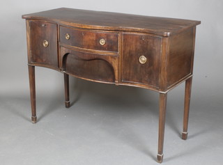 A Georgian style mahogany sideboard of serpentine outline fitted 2 drawers flanked by a pair of cupboards, raised on square tapering supports ending in spade feet 34 1/2"h x 47 1/2"w x 22"d 