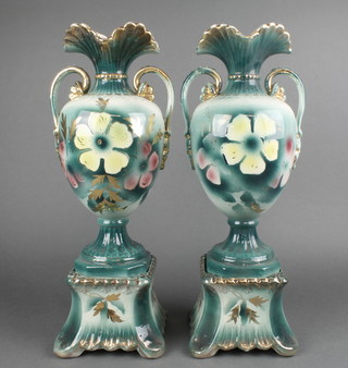 A pair of early 20th Century baluster vases with flared necks on raised bases with a turquoise ground decorated stylised flowers 8" 