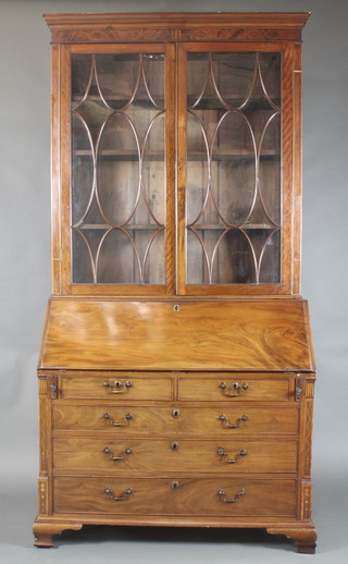 A handsome Georgian inlaid mahogany bureau bookcase, the upper section with moulded cornice fitted adjustable shelves enclosed by a pair of astragal glazed doors, the fall front revealing a well fitted interior fitted cupboards and drawers above 2 short and 3 long graduated drawers, with inlaid columns to the sides and raised on ogee bracket feet 94"h x 47"w x 20 1/2"d  