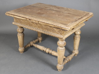 A Baltic State carved pine draw leaf dining table, the apron carved stylised roundels and raised on turned supports with H framed stretcher 29"h x 42"l when closed by 75"l when opened x 38"w 