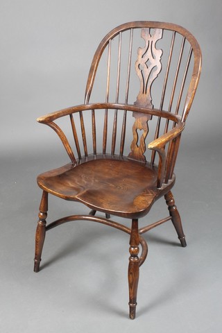 A 20th Century elm Windsor stick back chair with solid seat and crinoline stretcher, raised on turned supports with H framed stretcher 